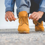 Turista si upravuje turistické topánky kvôli nepohodliu počas chôdze