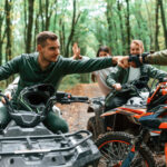 Can-Am ATV počas jazdy v prírode na lesnej ceste s výhľadom na hory.