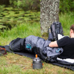 Turistický batoh 30l, spacák a nepremokavý stan pripravené na pobyt v prírode.