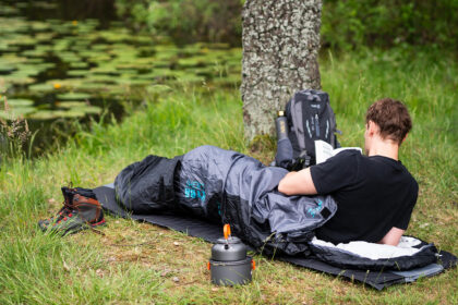 Turistický batoh 30l, spacák a nepremokavý stan pripravené na pobyt v prírode.