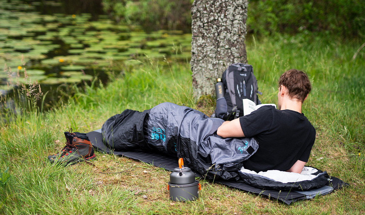 Turistický batoh 30l, spacák a nepremokavý stan pripravené na pobyt v prírode.